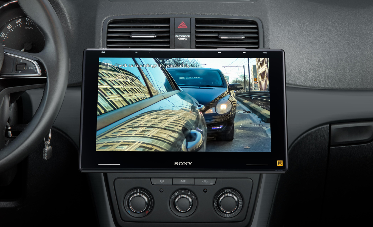 Indvendig visning af et instrumentbræt i en bil, der viser kameraet til parkeringshjælp i brug på XAV-9550ES